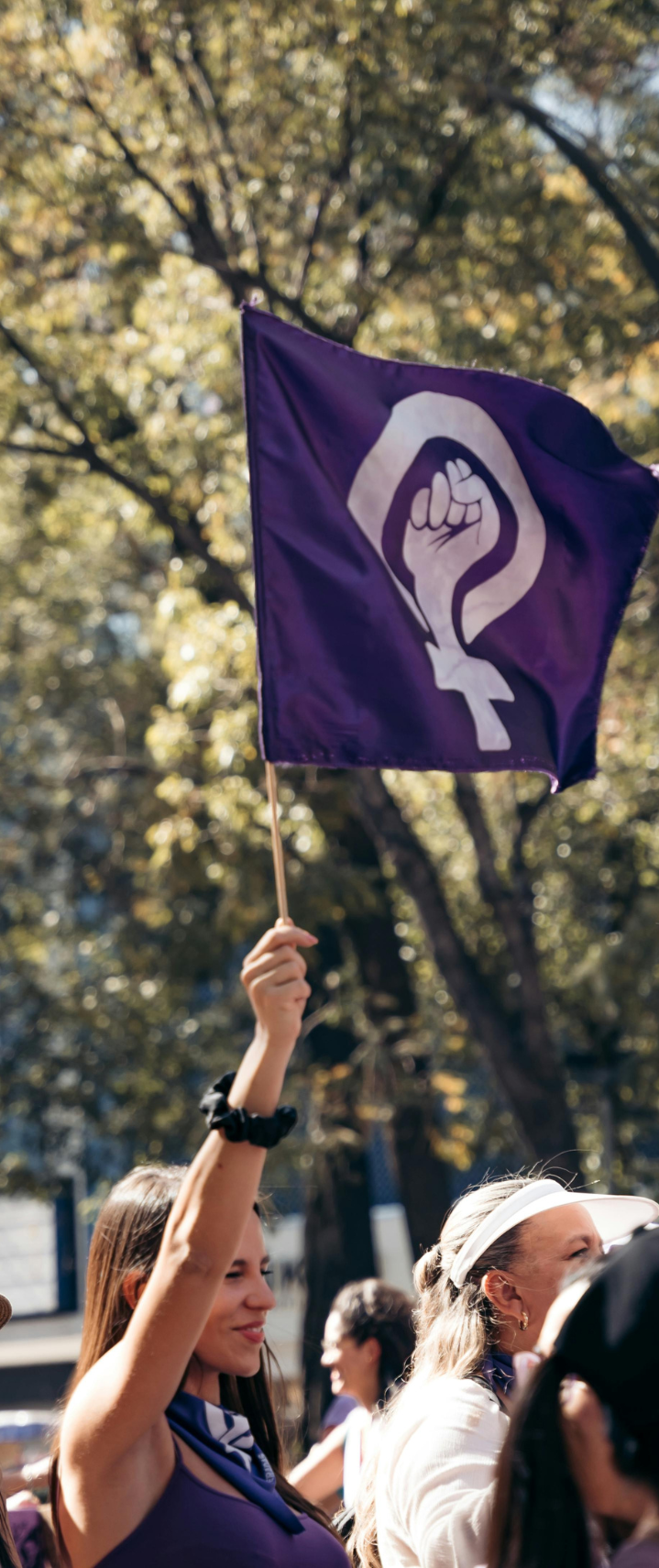 woman at a rally for womens rights holding a flag